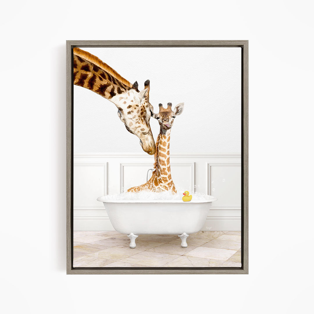A mother giraffe and her baby giraffe are sitting together in a white bathtub, with a yellow rubber duck floating in the water.