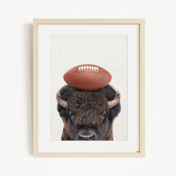 A buffalo with a football resting on its head.