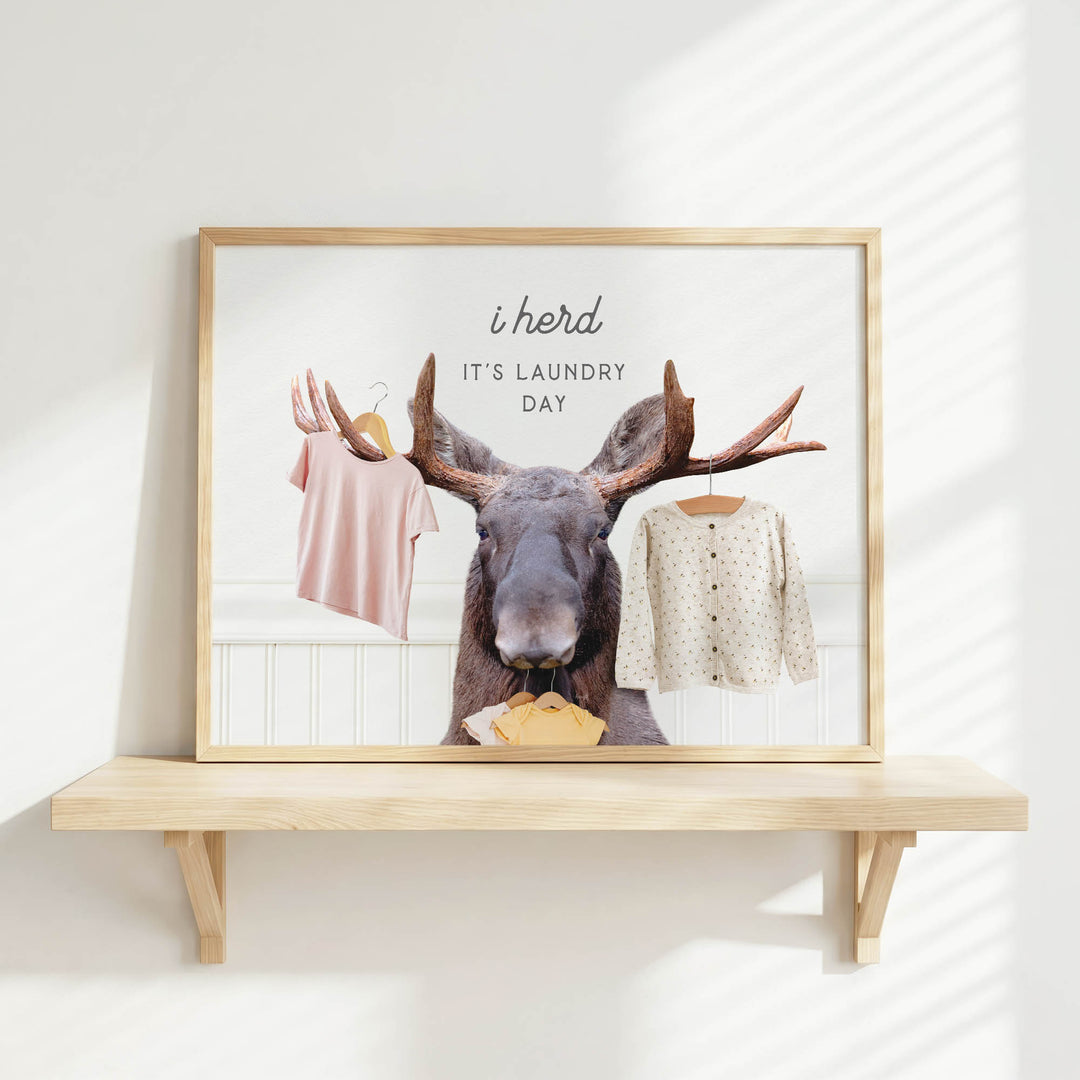 A framed image of a moose holding clothes, with the text "It's laundry day" written above it.