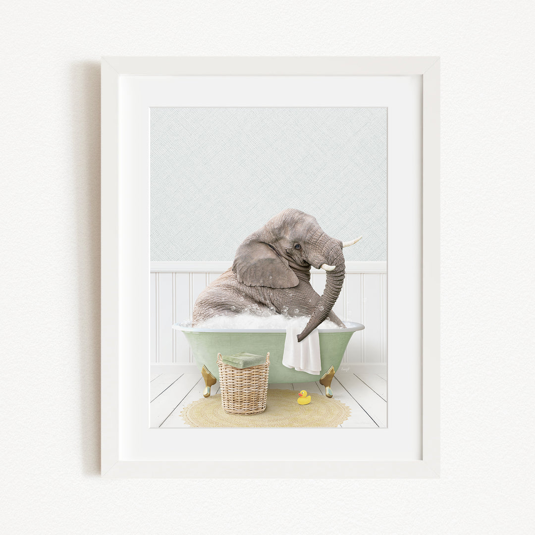 A gray elephant is sitting in a green bathtub filled with water, surrounded by a yellow rubber duck and a basket.