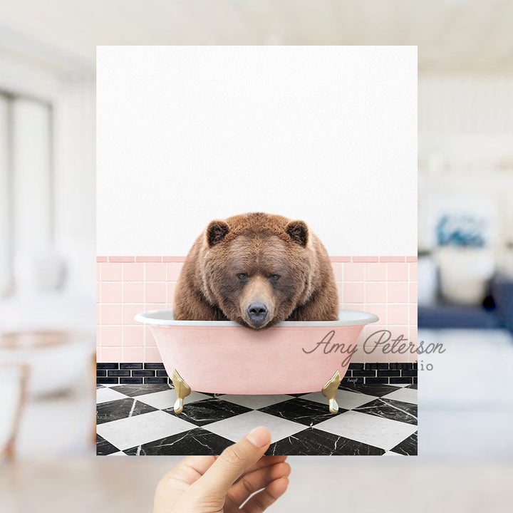 a person holding up a card with a bear in a bathtub