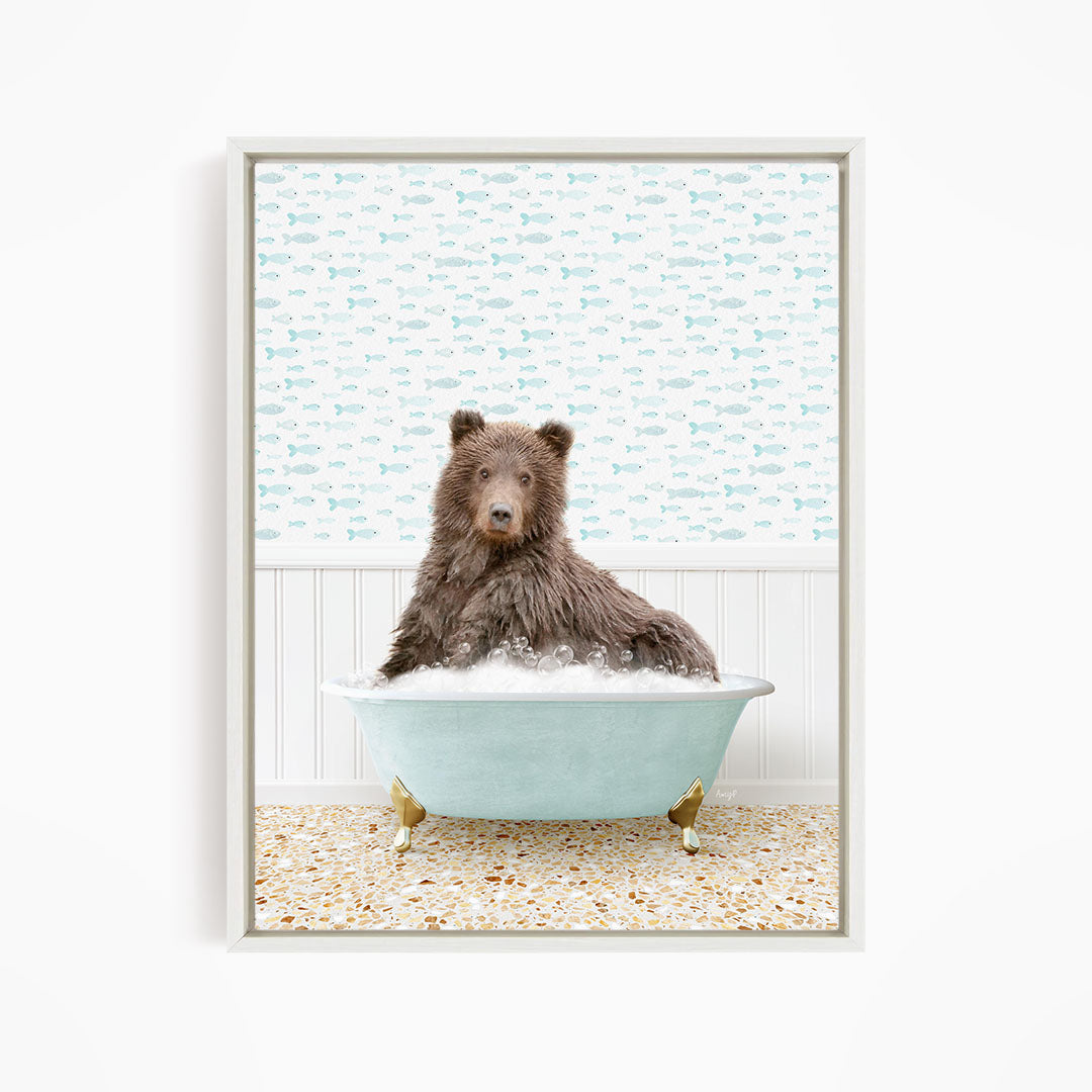 A brown bear sitting in a light blue bathtub filled with bubbles, surrounded by a pattern of fish.