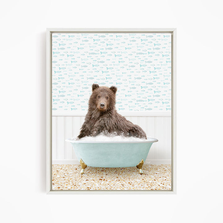 A brown bear sitting in a light blue bathtub filled with bubbles, surrounded by a pattern of fish.