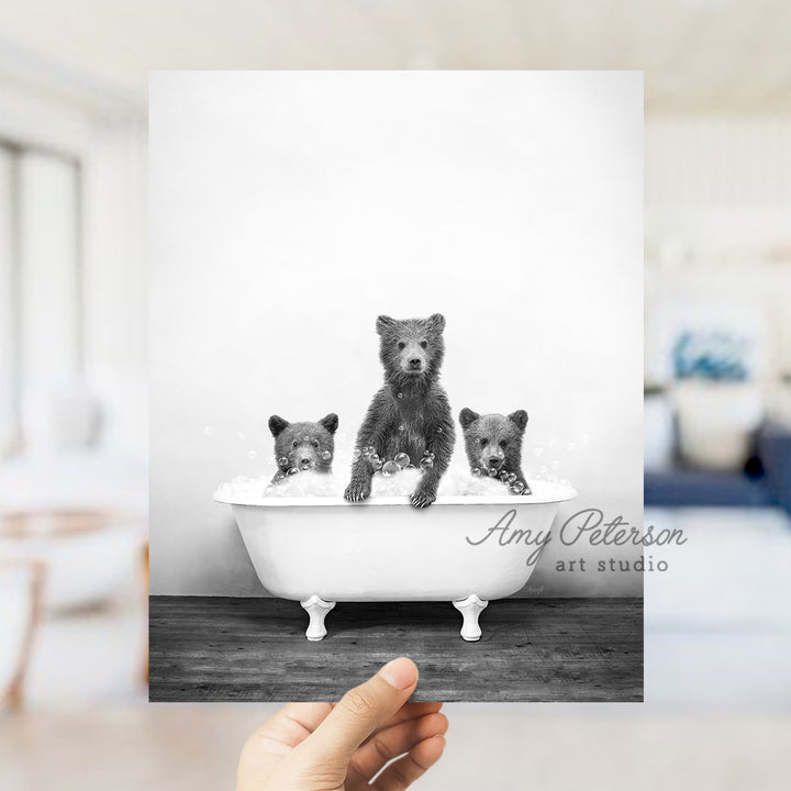 a black and white photo of three bears in a bathtub