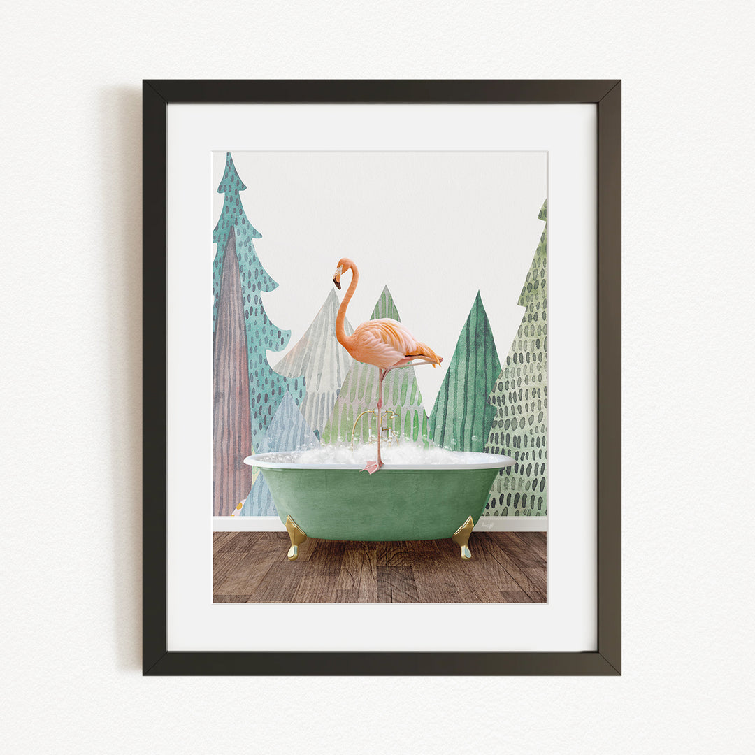 A framed print depicting a pink flamingo standing in a green bathtub, with a snowy landscape and pine trees in the background.