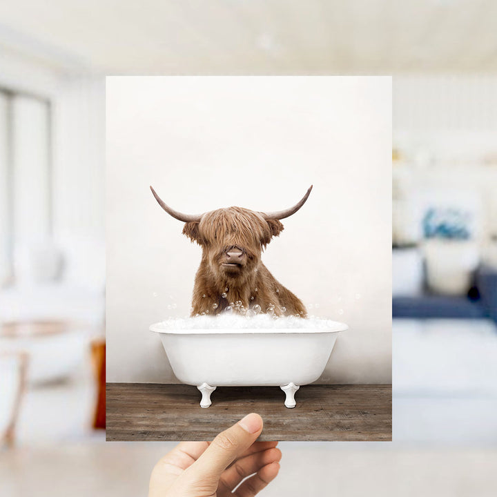 A brown cow with long horns is sitting in a white bathtub filled with water, creating a whimsical and amusing scene.