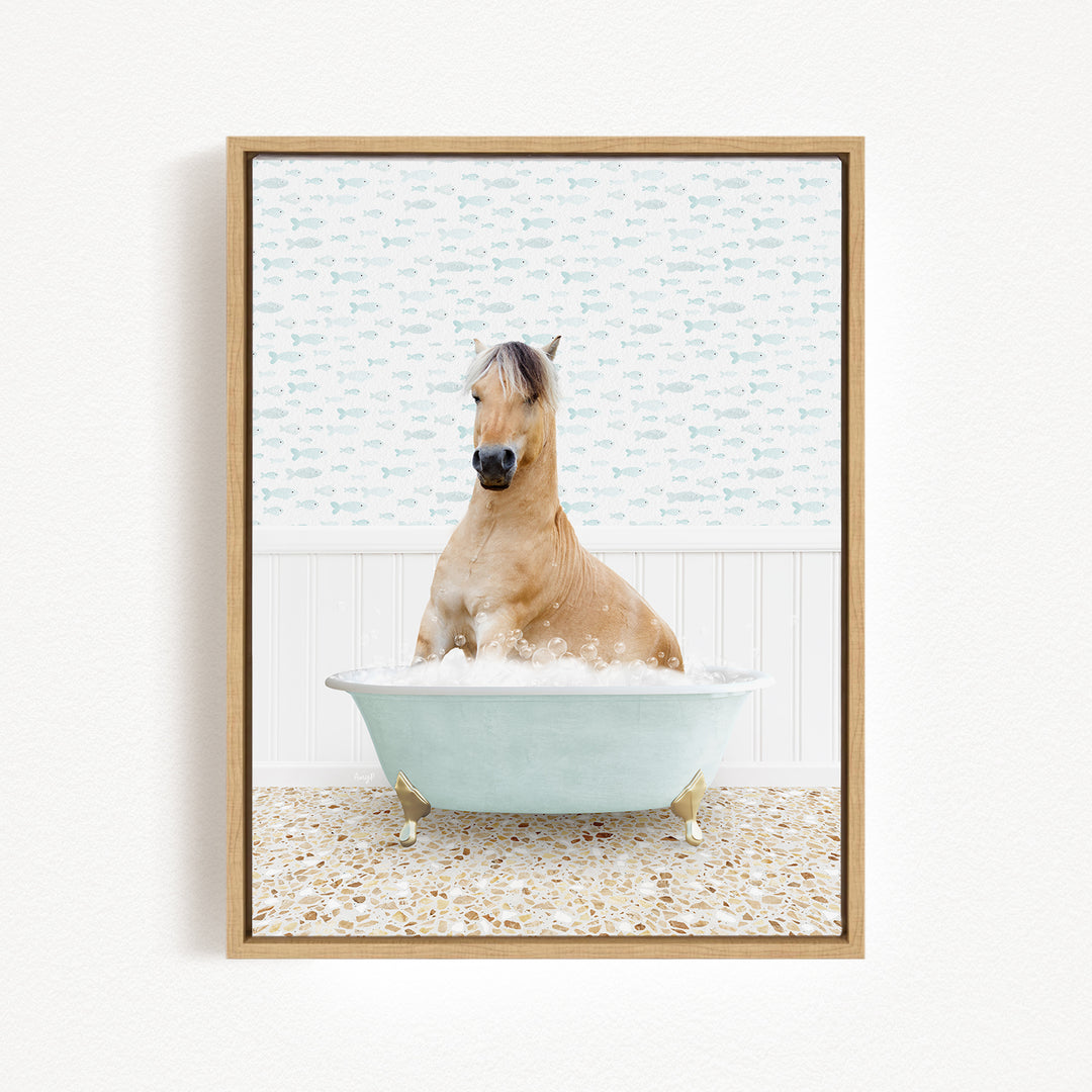 A light brown horse is sitting in a light blue bathtub filled with bubbles, surrounded by a patterned tile floor.