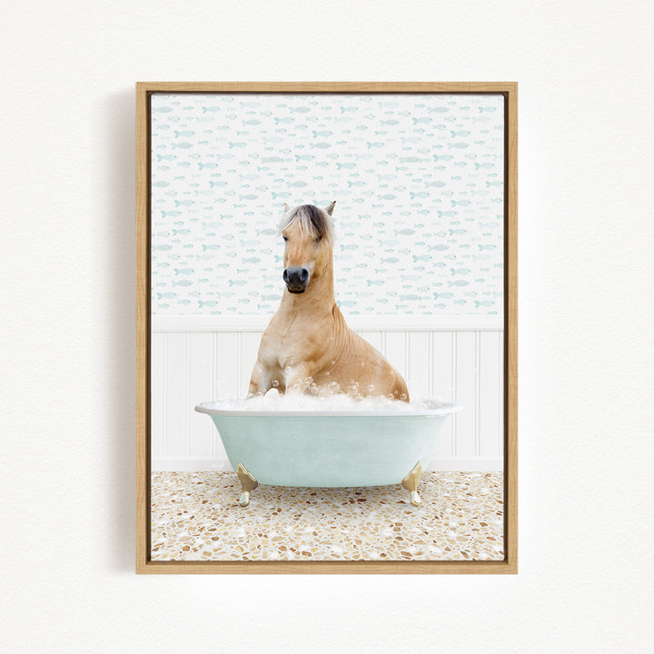 A light brown horse is sitting in a light blue bathtub filled with bubbles, surrounded by a patterned tile floor.