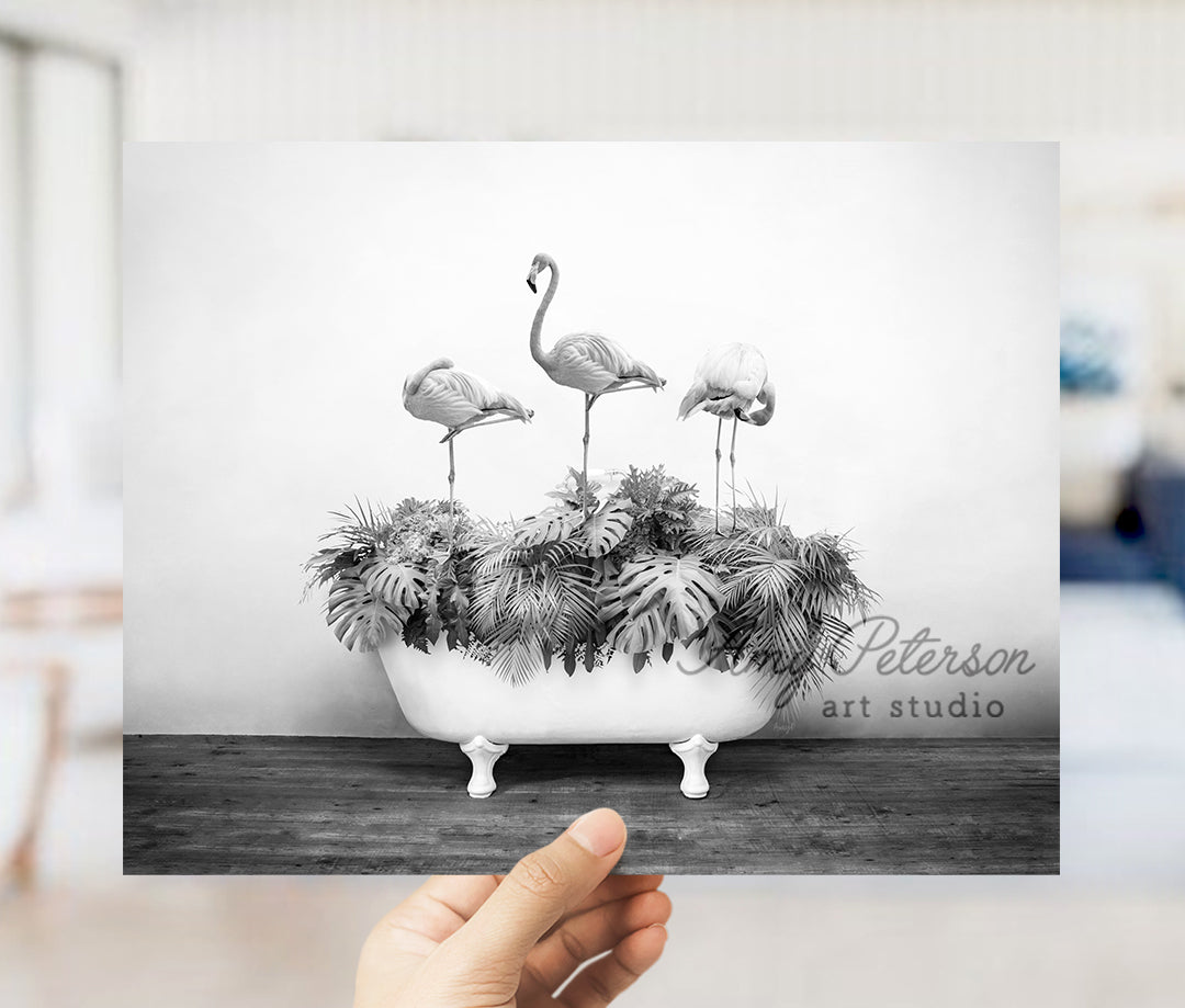 a black and white photo of three flamingos in a bathtub