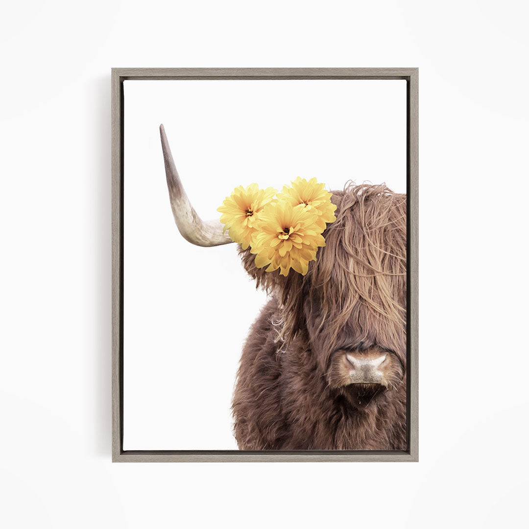 A close-up of a brown cow with large horns, adorned with yellow flowers on its head.
