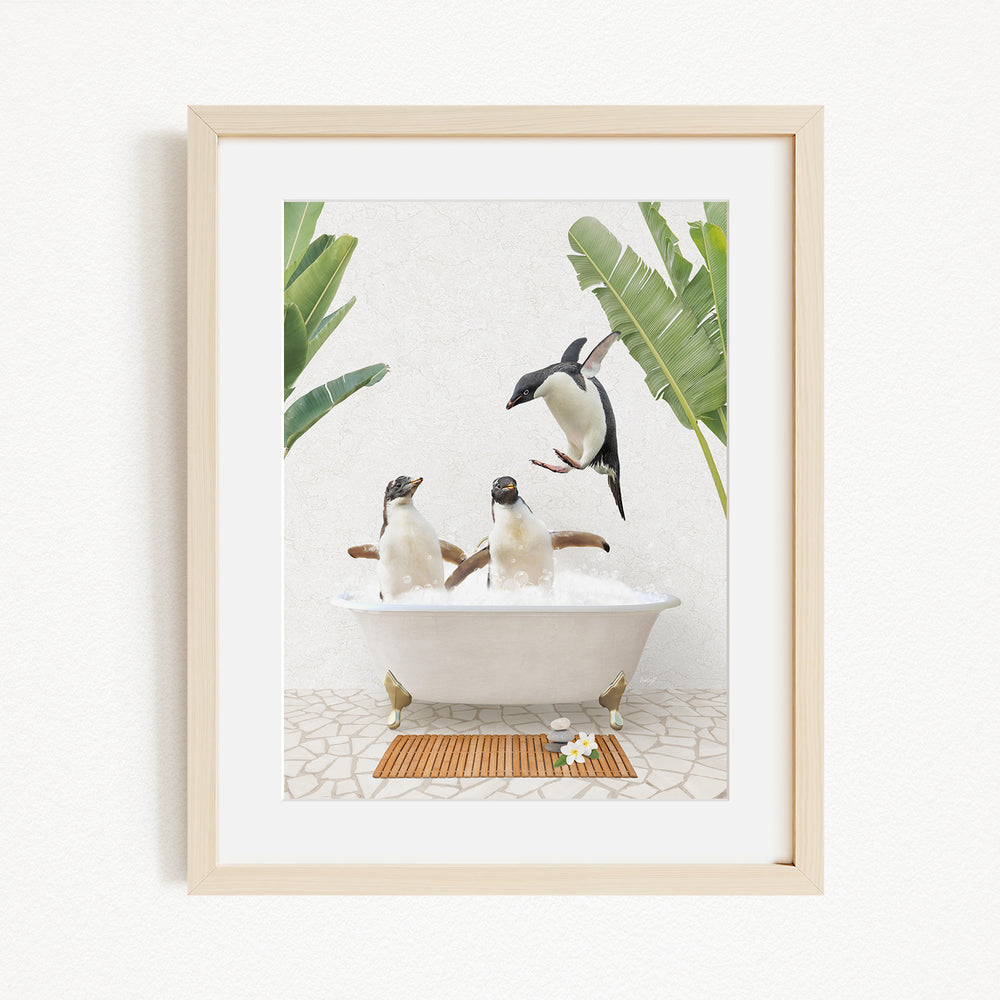 A framed image depicting three penguins sitting in a bathtub, surrounded by tropical plants.