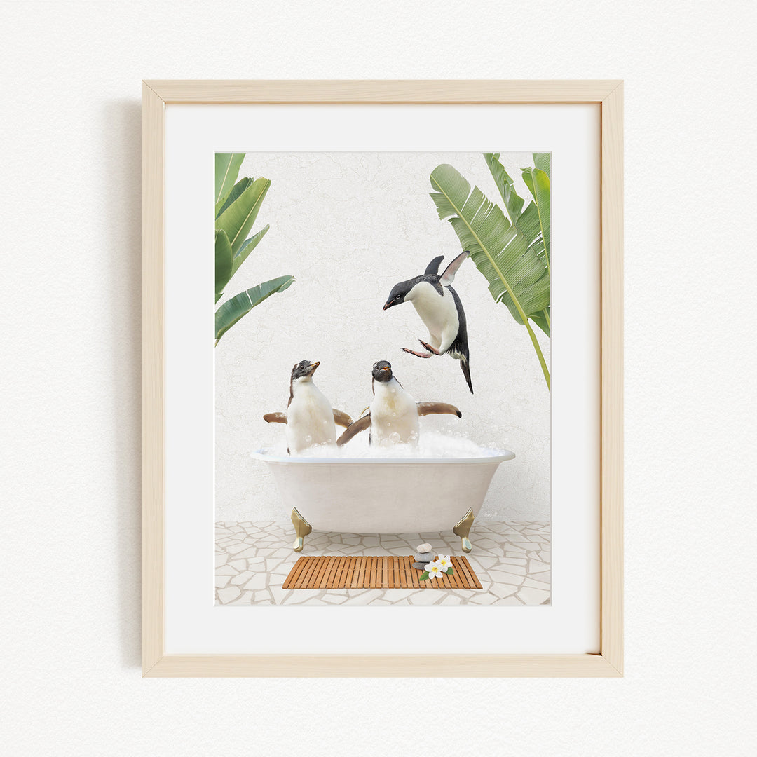 A framed image depicting three penguins sitting in a bathtub, surrounded by tropical plants.