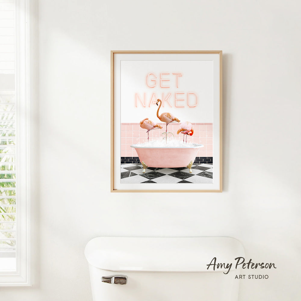 a framed poster with the text "GET NAKED" and an illustration of three flamingos in a pink bathtub.
