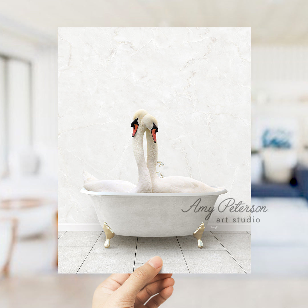 a person holding up a picture of two swans in a bathtub