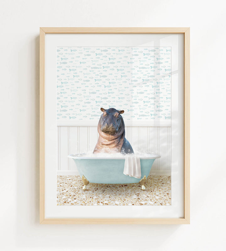 A framed image depicting a hippopotamus sitting in a bathtub filled with water, surrounded by a patterned wall.