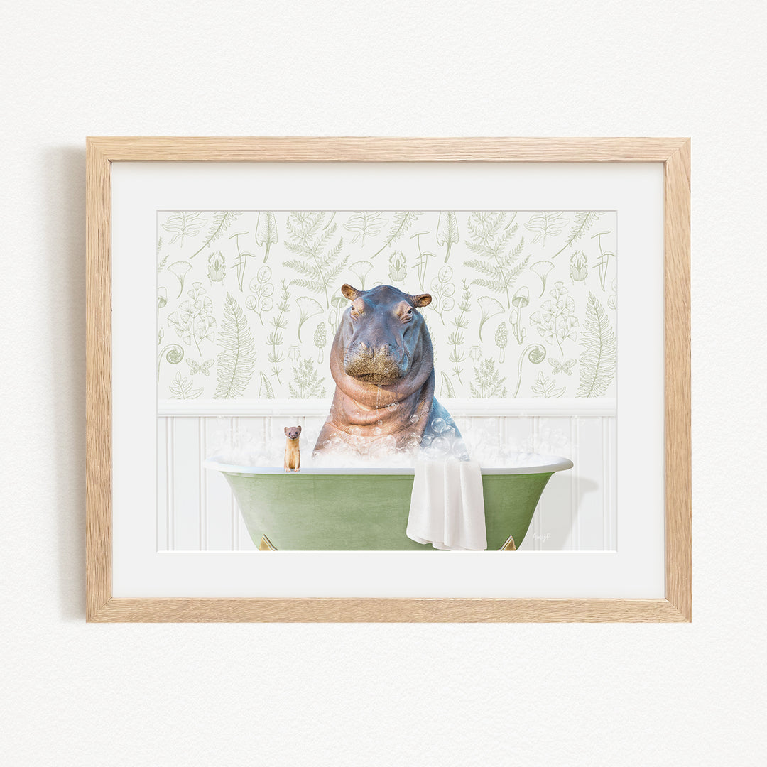 A hippopotamus sitting in a green bathtub, surrounded by a towel and a small animal, against a backdrop of green ferns.