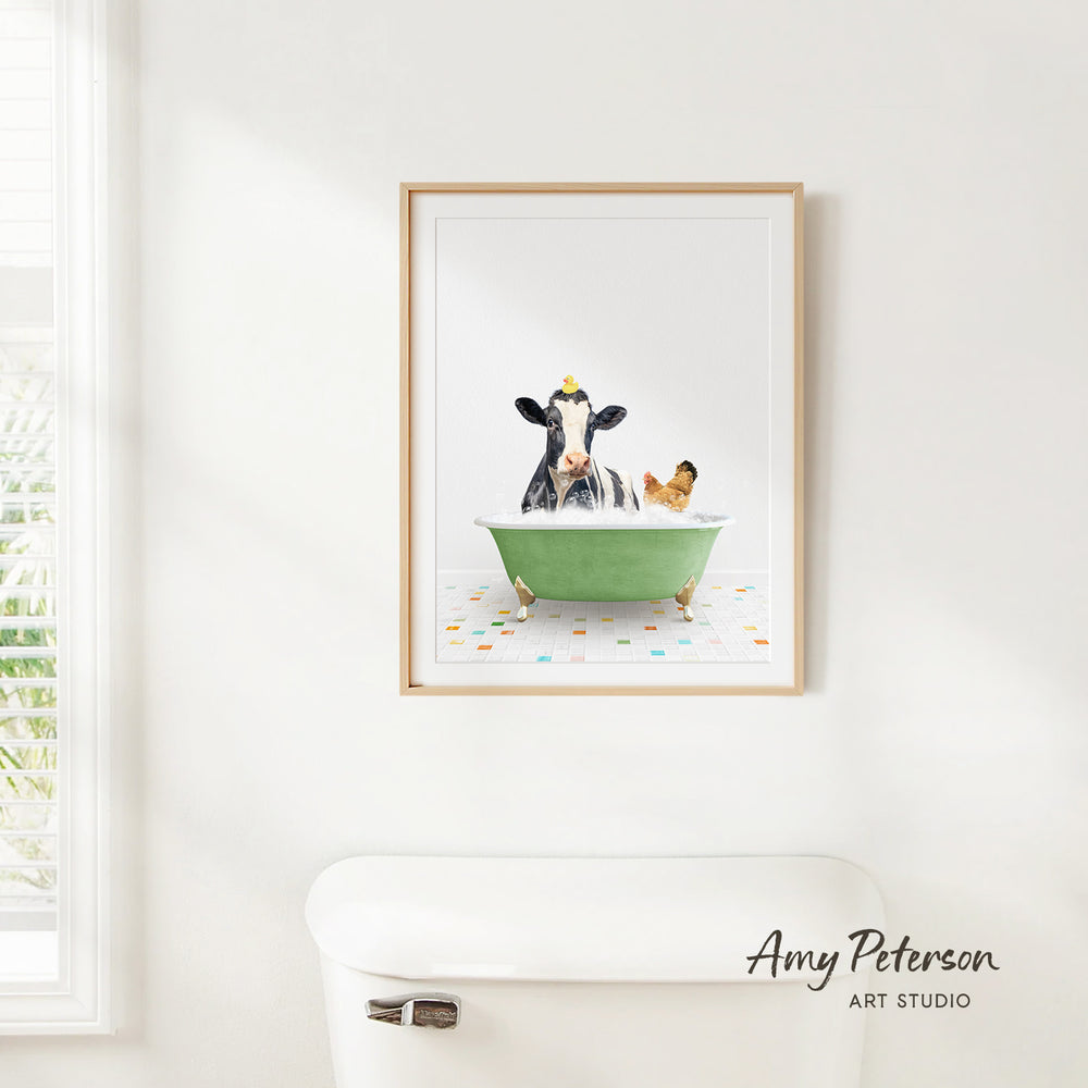 A framed image of a cow sitting in a green bathtub, with a chicken nearby, is hanging on a white wall.