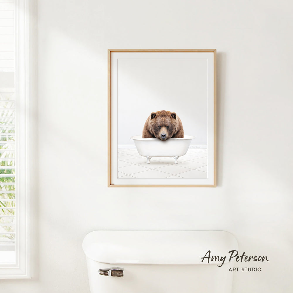 A framed image of a brown bear sitting in a white bathtub, with the caption " Amy Peterson ART Studio" below the frame.