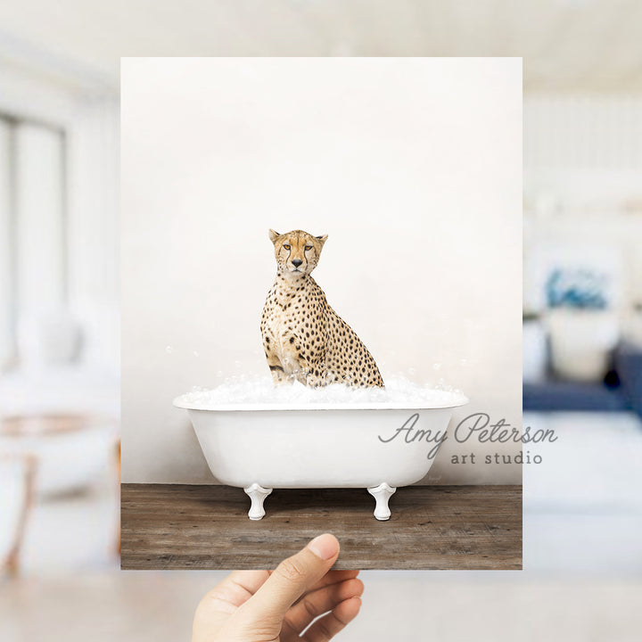 a hand holding up a photo of a cheetah in a bathtub