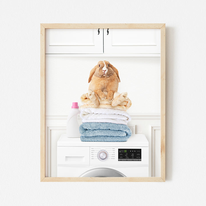 a rabbit sitting on top of a stack of towels