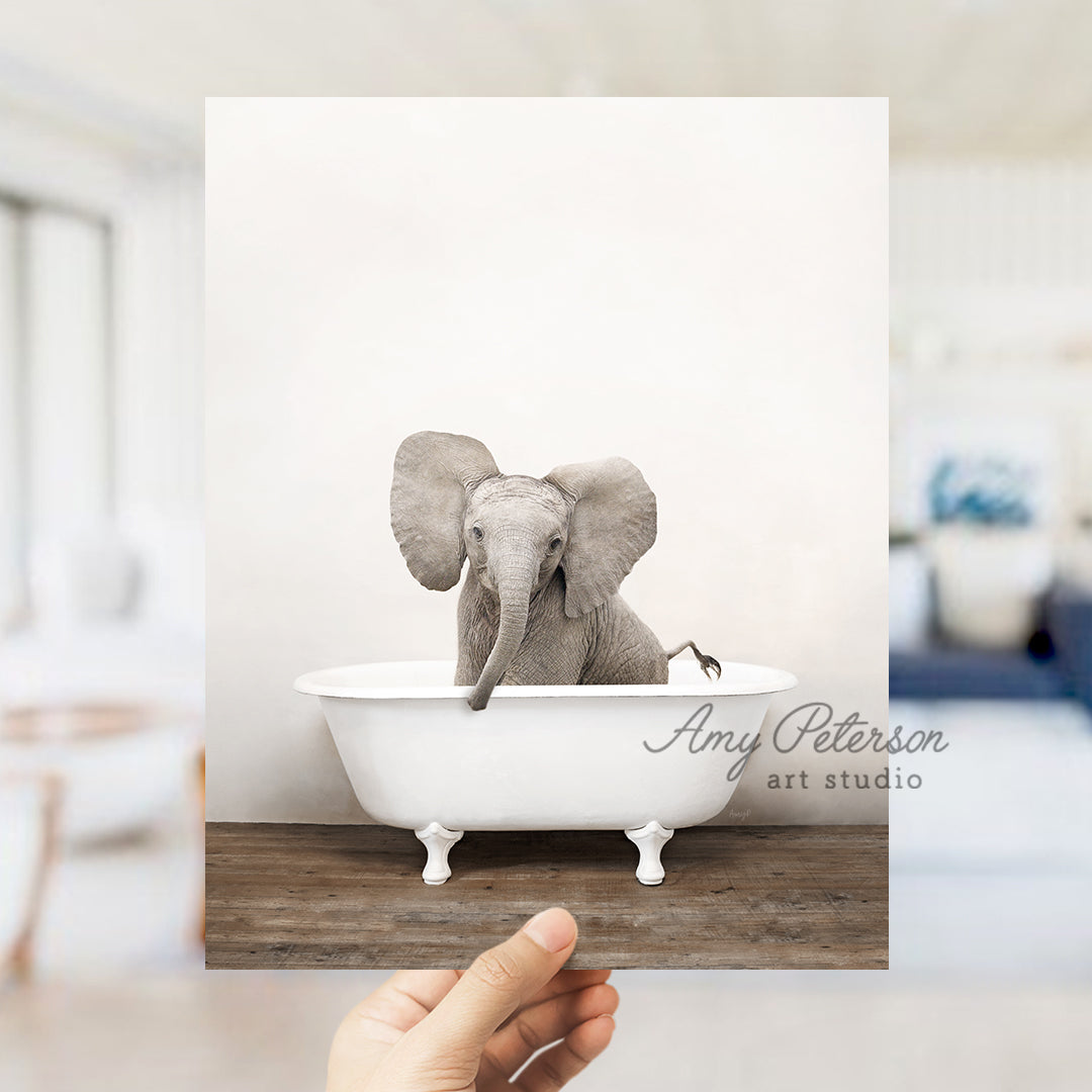 a hand holding up a card with an elephant in a bathtub