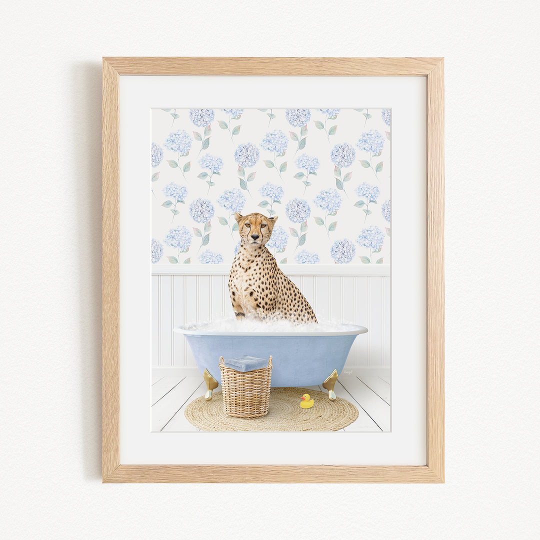 A cheetah sitting in a blue bathtub filled with water, surrounded by a floral patterned wall and a basket of rubber ducks.