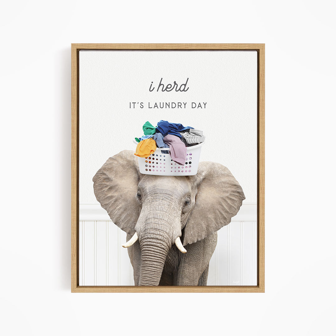 A gray elephant holding a basket of clothes on its head, with the text "i herd IT'S Laundry Day" above it.