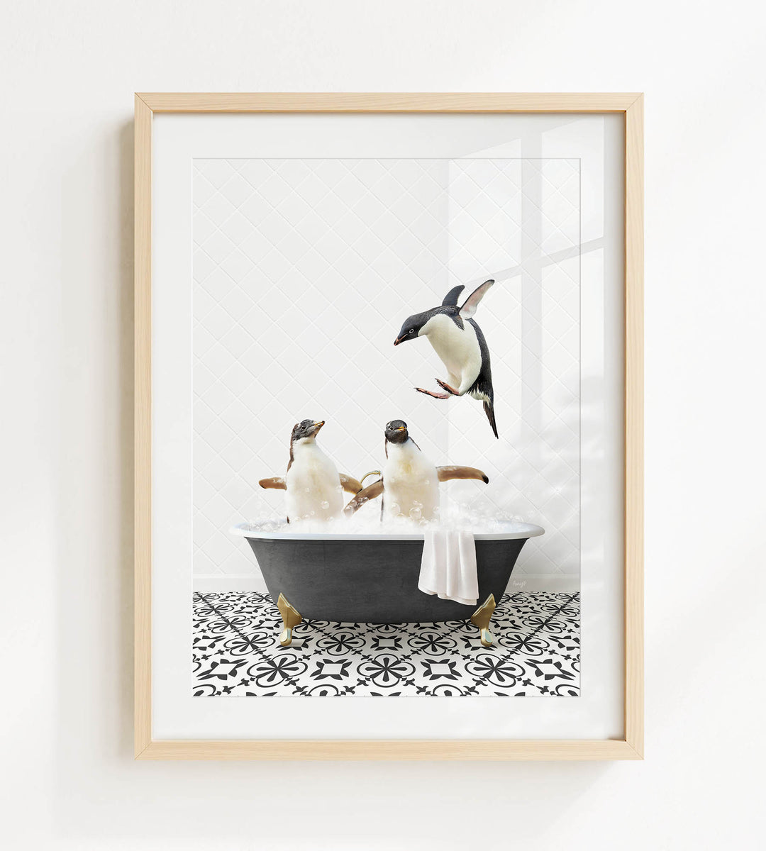 A framed image depicting three penguins sitting in a bathtub, with one penguin flying towards the others.