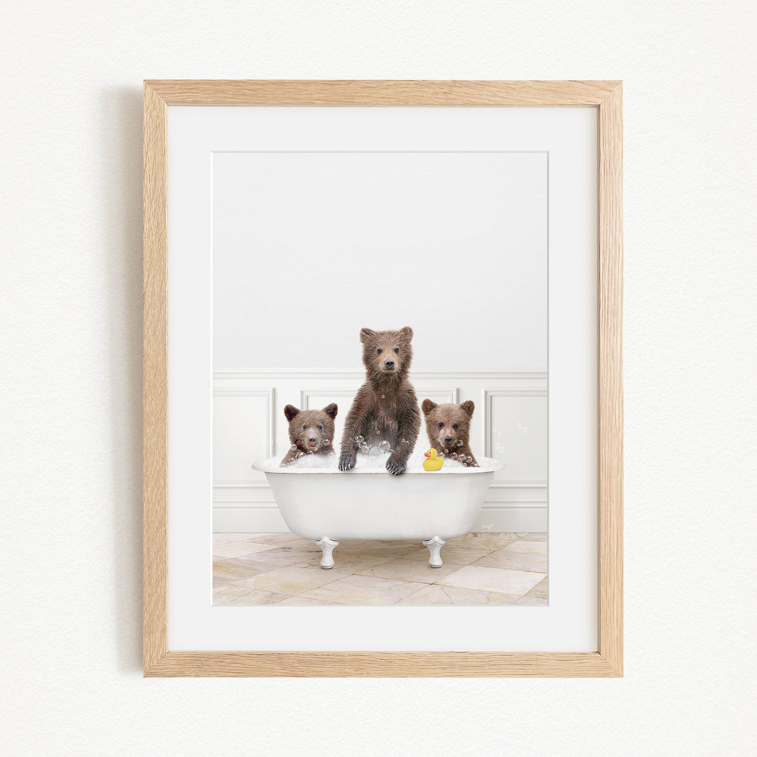 A framed image of three bears sitting in a white bathtub, with one bear holding a rubber duck.