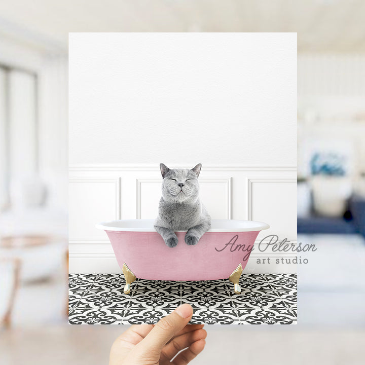 a person holding a card with a cat in a bathtub