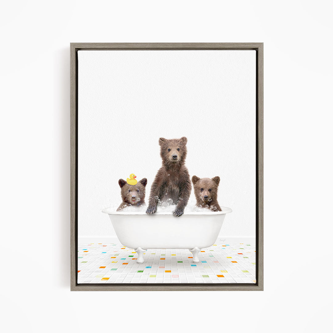 A framed image depicting three bears sitting in a white bathtub filled with water, with a colorful tiled floor beneath them.