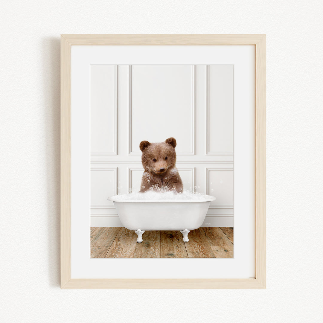 A brown bear sitting in a white bathtub filled with water, looking at the camera.