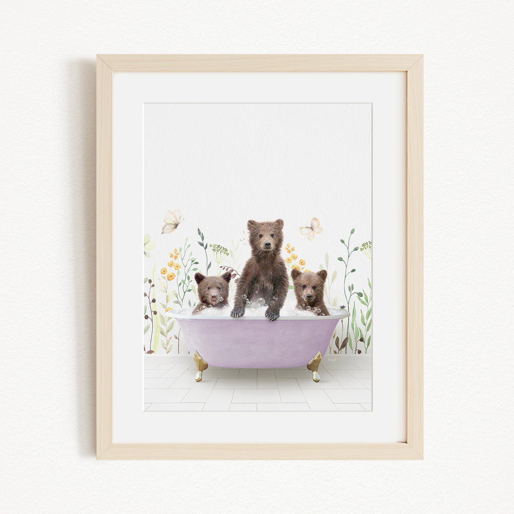 A framed image depicting three bears sitting in a bathtub filled with water, surrounded by flowers and butterflies.