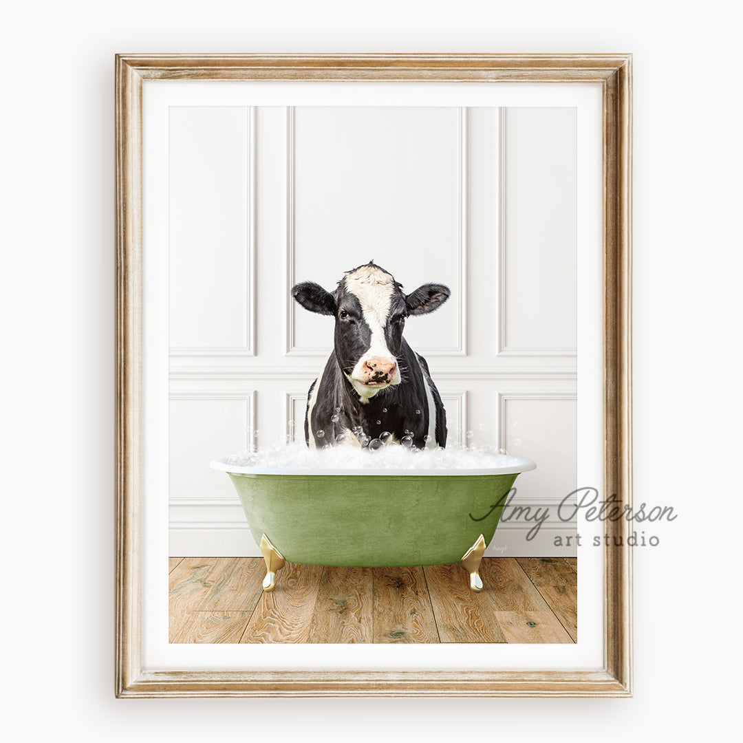 a black and white cow sitting in a green bath tub