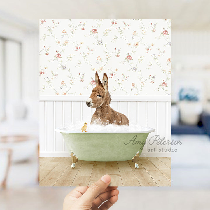 a hand holding a photo of a dog in a bathtub