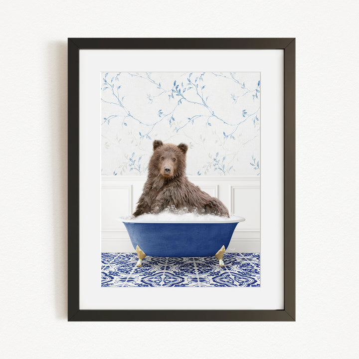 A brown bear sitting in a blue bathtub filled with bubbles, with a patterned tile floor and a floral wallpaper in the background.