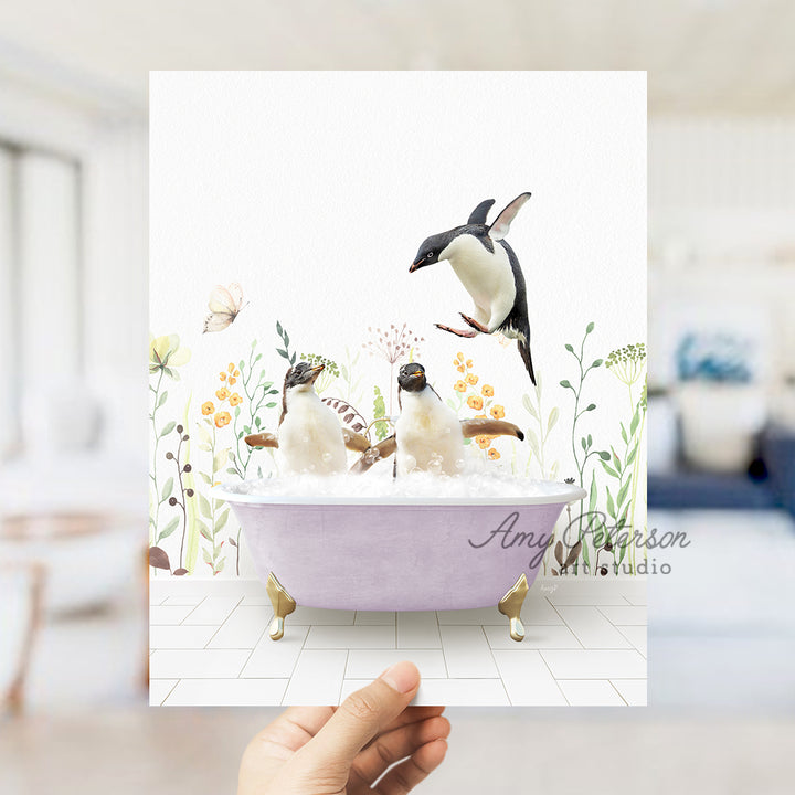 a hand holding up a card with penguins in a bathtub