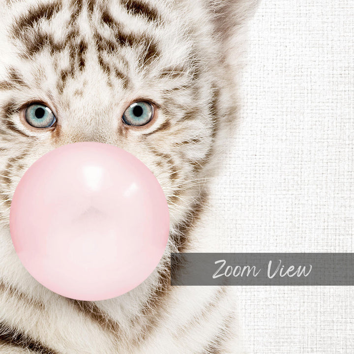 A close-up of a cat's face with its eyes open, looking directly at the camera, and blowing a pink bubble with a bubble gum bubble wand.