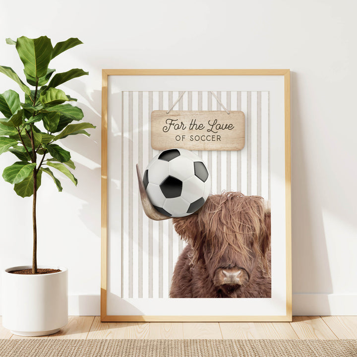 a framed poster with a soccer ball and a cow's head, along with a wooden sign that says "For the Love of Soccer".