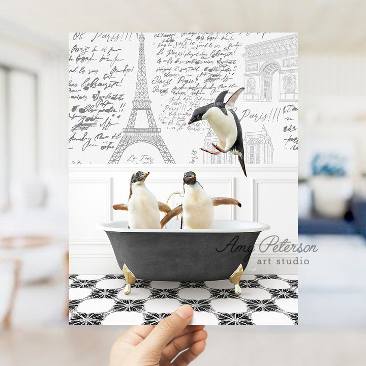 a person holding up a card with penguins in a bathtub