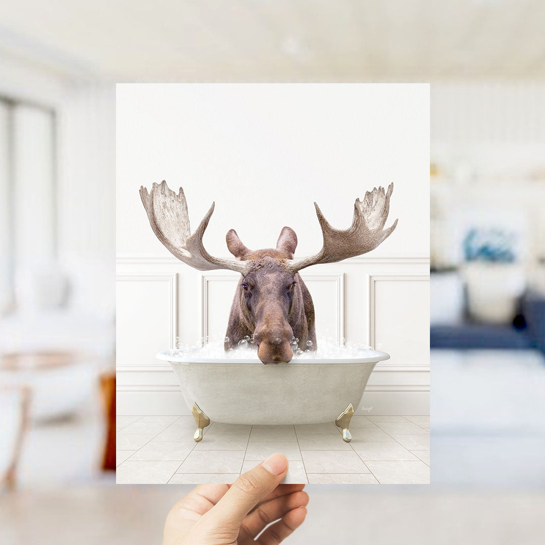 A moose with large antlers is sitting in a bathtub filled with water, creating a whimsical and humorous scene.