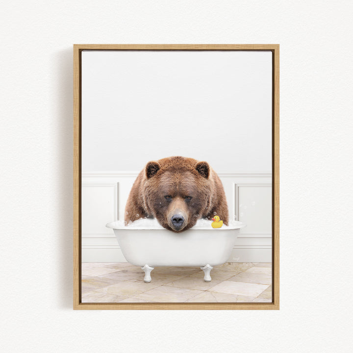 A brown bear is sitting in a white bathtub, with a rubber duck floating in the water.