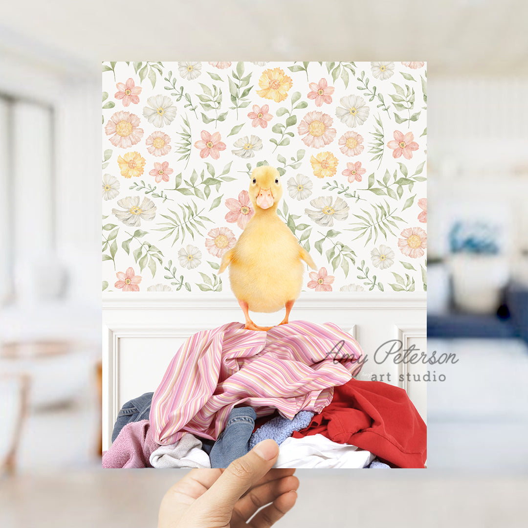 a person holding up a picture of a duck on a pile of clothes