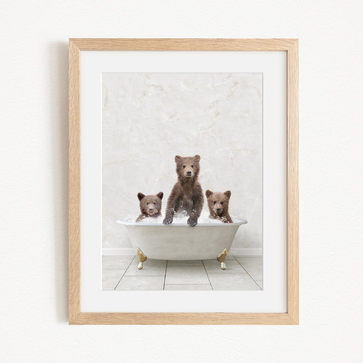 A framed image depicting three bears sitting in a bathtub, with one bear sitting in the center and the other two bears sitting on either side.