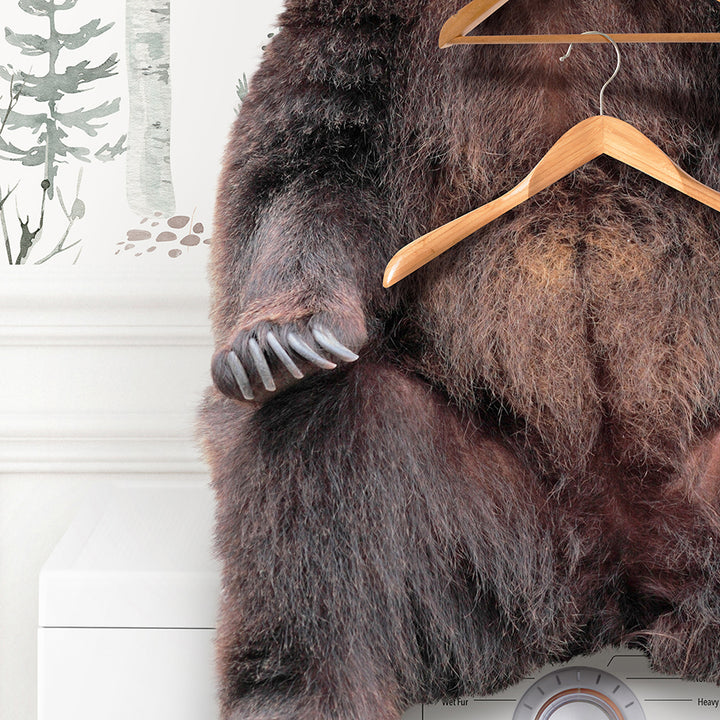 a brown bear sitting on top of a dryer