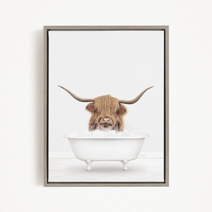 A Highland cow with long horns is sitting in a white bathtub filled with water, appearing to enjoy the bath.