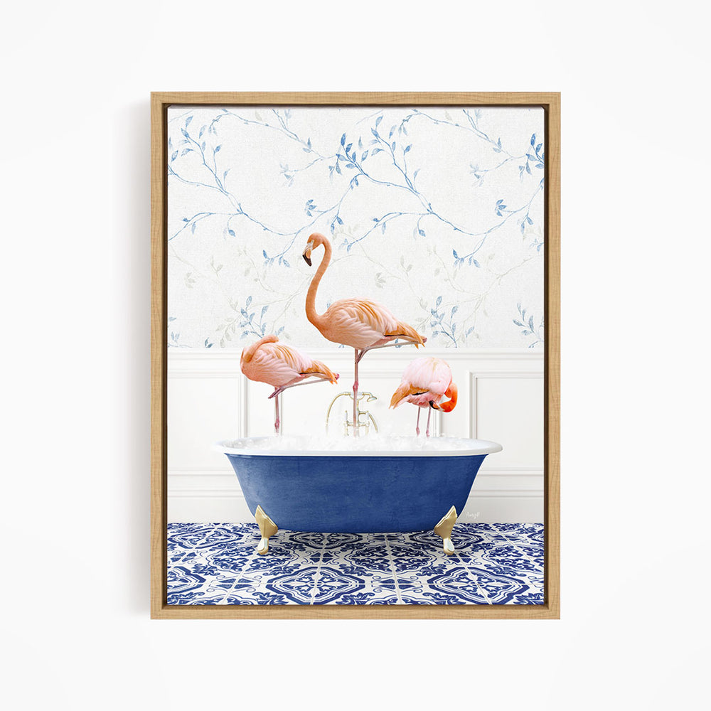 A framed image depicting three flamingos standing in a blue bathtub, with a patterned tile floor and a floral wallpaper in the background.