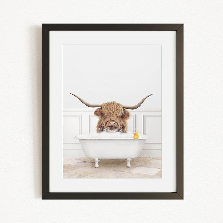 A Highland cow with long horns is sitting in a white bathtub, surrounded by a yellow rubber duck.