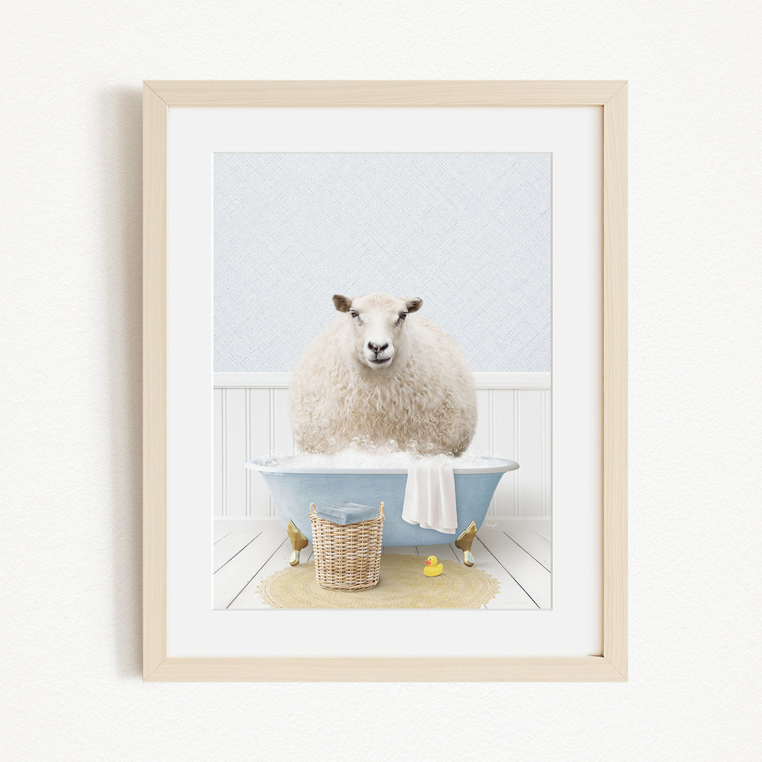 A fluffy white sheep sits in a blue bathtub filled with bubbles, surrounded by a yellow rubber duck and a basket.