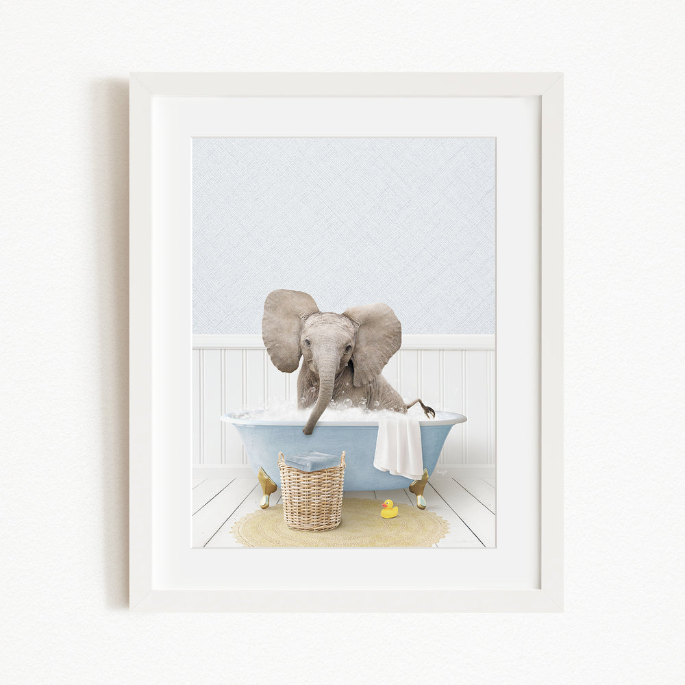 A baby elephant sitting in a blue bathtub, surrounded by a yellow rubber duck and a basket of toys.